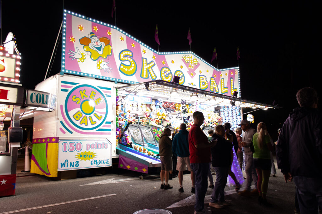 Skee Ball Vendor Game Truck. Patrons are walking around enjoying the event while some play a game of skee ball