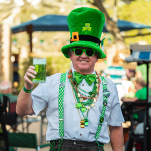Patron dressed up for St. Patrick's Day holding green beer