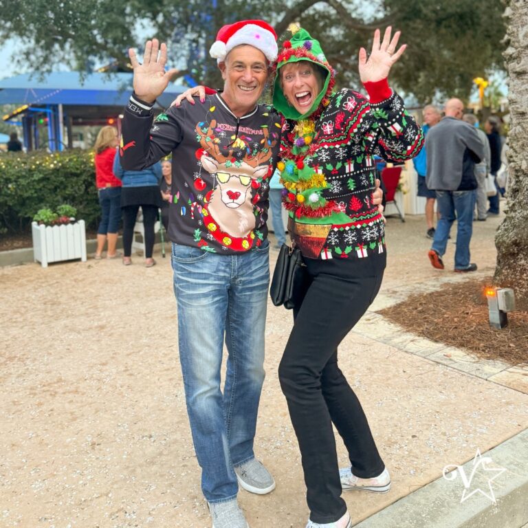 Two people posing in festive sweaters