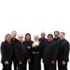Groove Slayers, a female fronted band of 9, pose and smile. All members are wearing black.