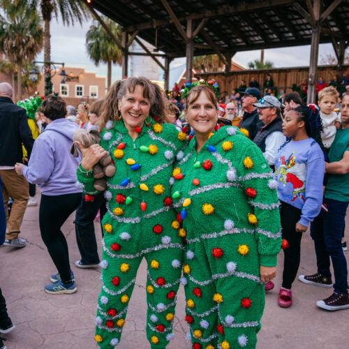 A group of people in green costumes, possibly for a festive occasion.