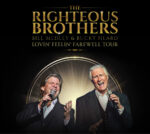 Promotional image for The Righteous Brothers’ Lovin’ Feelin’ Farewell Tour. Singers Bill Medley and Bucky Heard are shown mid-performance, each holding a microphone. The background features a glowing circular spotlight effect, with the group’s name in large gold lettering above them.
