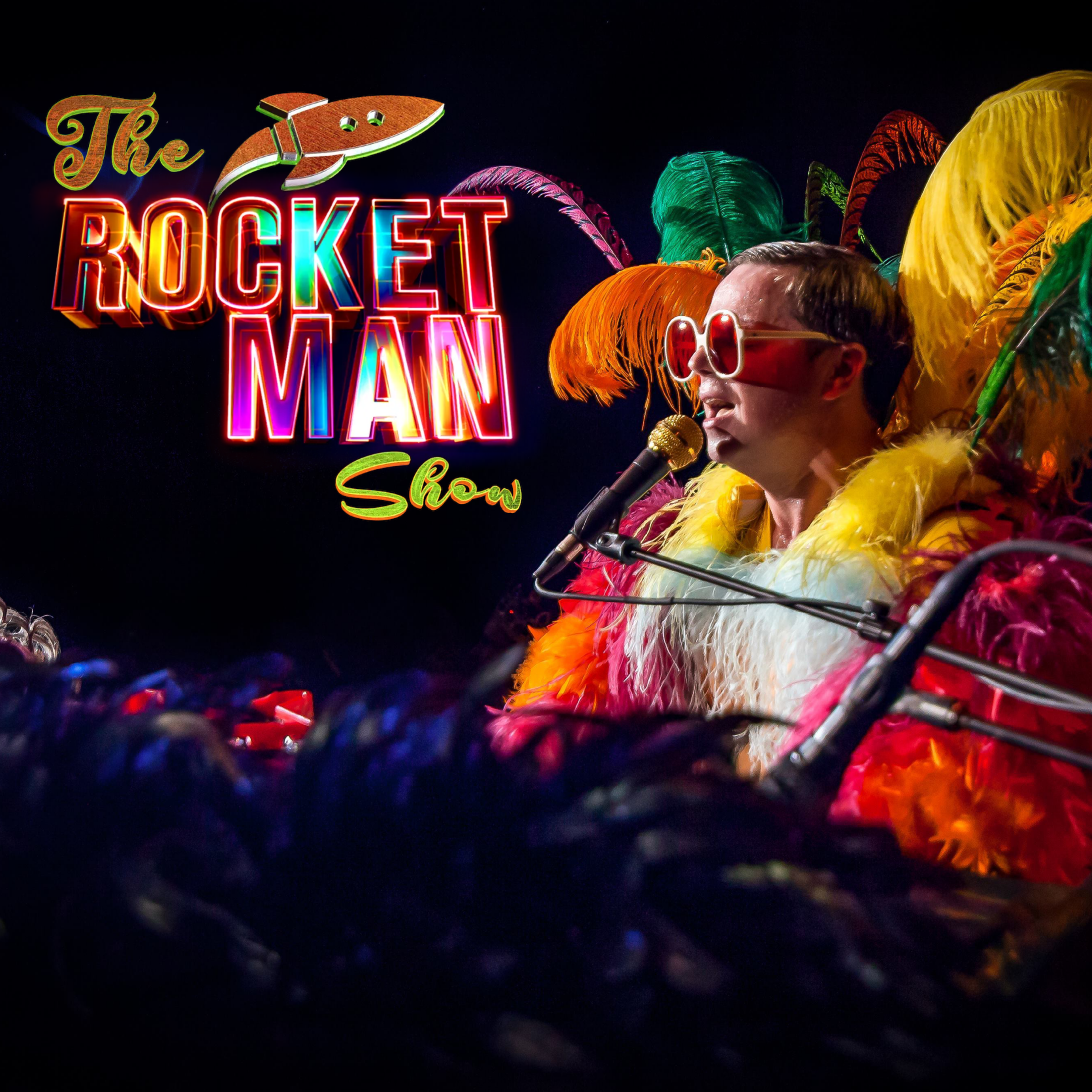 Promotional poster for The Rocket Man Show. A performer wearing many bright feathers is pictured playing a piano while singing. In the top left corner is a colorful logo including a rocket and text that reads: "The Rocket Man Show."