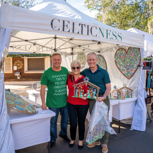 Customers pose with a carefully crafted nativity scene and the artist who created it.