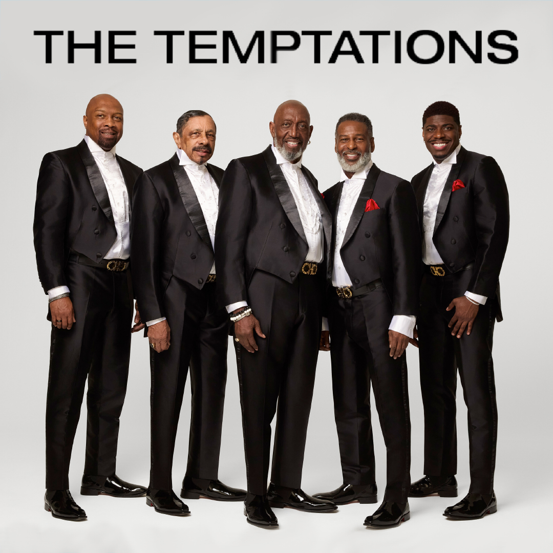 The five current members of The Temptations are wearing black tuxedos, with red flowers on their lapels, and pointing at the viewer. They are standing in front of a light gray background. The text at the top of the image in black, all capital lettering, says "THE TEMPTATIONS."