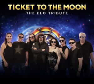 Picture of the band members wearing black clothing and sunglasses in front of a space background.