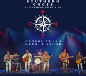 The design features a deep blue concert‑style background with colorful stage lighting beams. Centered near the top is a compass‑rose graphic with red letters marking cardinal directions replaced with S, N, Y, and C, beneath the title text “Southern Cross” and “The Musical Tribute to Crosby, Stills, Nash & Young.” Along the bottom, a full band performs live on stage, with multiple musicians playing acoustic and electric guitars, bass, keyboards, and drums, standing across a wide stage setup with amplifiers and microphone stands.