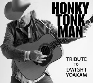A musician wearing a wide‑brimmed cowboy hat and denim jacket plays an acoustic guitar in a dynamic pose against a plain white background. Bold black text on the right reads “HONKY TONK MAN,” with smaller stacked text below reading “TRIBUTE TO DWIGHT YOAKAM.”