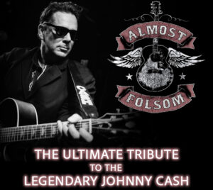 The left side shows a black‑and‑white performance photo of a musician holding and playing an acoustic guitar, wearing dark stage clothing against a black background. On the right is a distressed emblem featuring a guitar with wings and a banner reading “Almost Folsom.” At the bottom, bold glowing text reads “The Ultimate Tribute to the Legendary Johnny Cash.” The overall design is dramatic and minimal, with high contrast and a classic country‑music aesthetic.