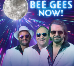 Promotional poster for Bee Gees Now! 3 men are pictured wearing suits and sunglasses in front of a disco ball with neon lights illuminating it.