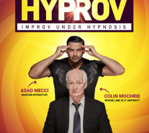 Artwork for "HYPROV - Improv Under Hypnosis." The show title is at the top of the image in a black rectangle. There is a soft glow coming through the word "Hyprov" between the letters "P" and "R." Below the show title, Asad and Colin are posing together. Colin is looking at the camera with a wide-eyed expression, and Asad stands above him with a focused look on his face. Asad's hands are at his temples, implying he is trying to hypnotize the viewer. The performers' names and titles appear on either side of the pair with small red arrows pointing to whom they refer. To the left reads "Asad Mecci, Master Hypnotist." On the right side of the two are the words "Colin Mochrie, followed by the title of the show he is most well-known from, "Whose Line Is It Anyway?" The background of the artwork is a swirl of gradient colors ranging in red, purple, orange, and yellow.