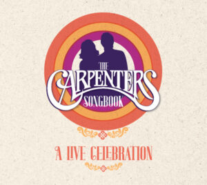 A promotional graphic titled “The Carpenters Songbook: A Live Celebration.” Two silhouetted figures appear at the center, framed by concentric circular bands in shades of orange, yellow, and purple on a light textured background. Decorative flourishes appear above and below the subtitle.