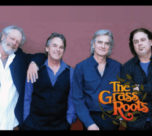 The Grass Roots 4-piece band poses in front of a mauve wall. The band logo, with orange text and olive-colored leave surrounding it, is displayed at the bottom right.
