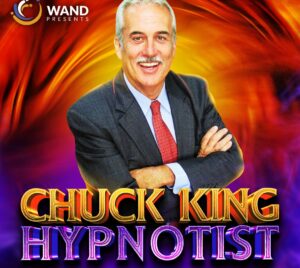 Promotional graphic featuring a person in a dark suit and red tie, standing with arms crossed against a vibrant, swirling background of orange, red, and purple tones. Large stylized text at the bottom reads “CHUCK KING HYPNOTIST.” In the top left corner, a logo reads “WAND PRESENTS.”