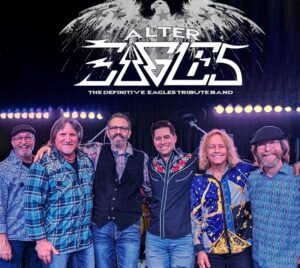 Photo of 6 group members on a stage with a string of lights behind them. The title "Alter Eagles - The Definitive Eagles Tribute Band" is written at the top.