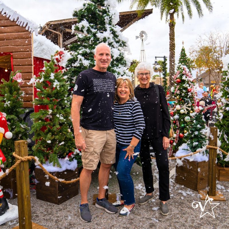 Three people posing in winter display